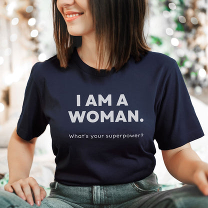 Person wearing a blue feminist t-shirt with 'I AM A WOMAN. What's your superpower?' text.