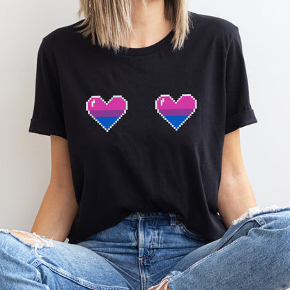 Person wearing a black t-shirt with pixelated bisexual pride hearts design.