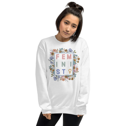 Person wearing a white sweatshirt with floral 'FEMINIST' design on a white background