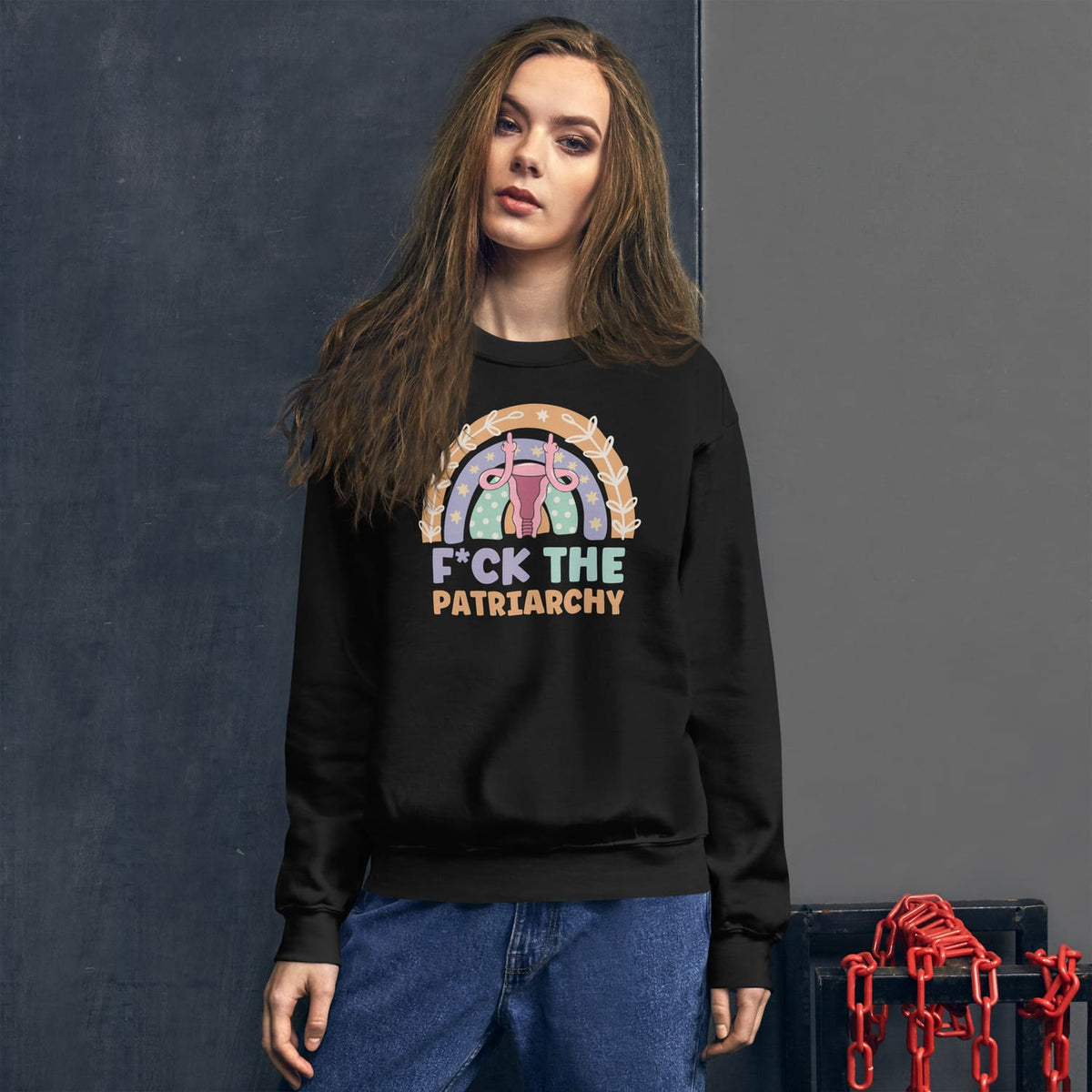 Person wearing a black sweatshirt with feminist design and text, standing against a dark background.