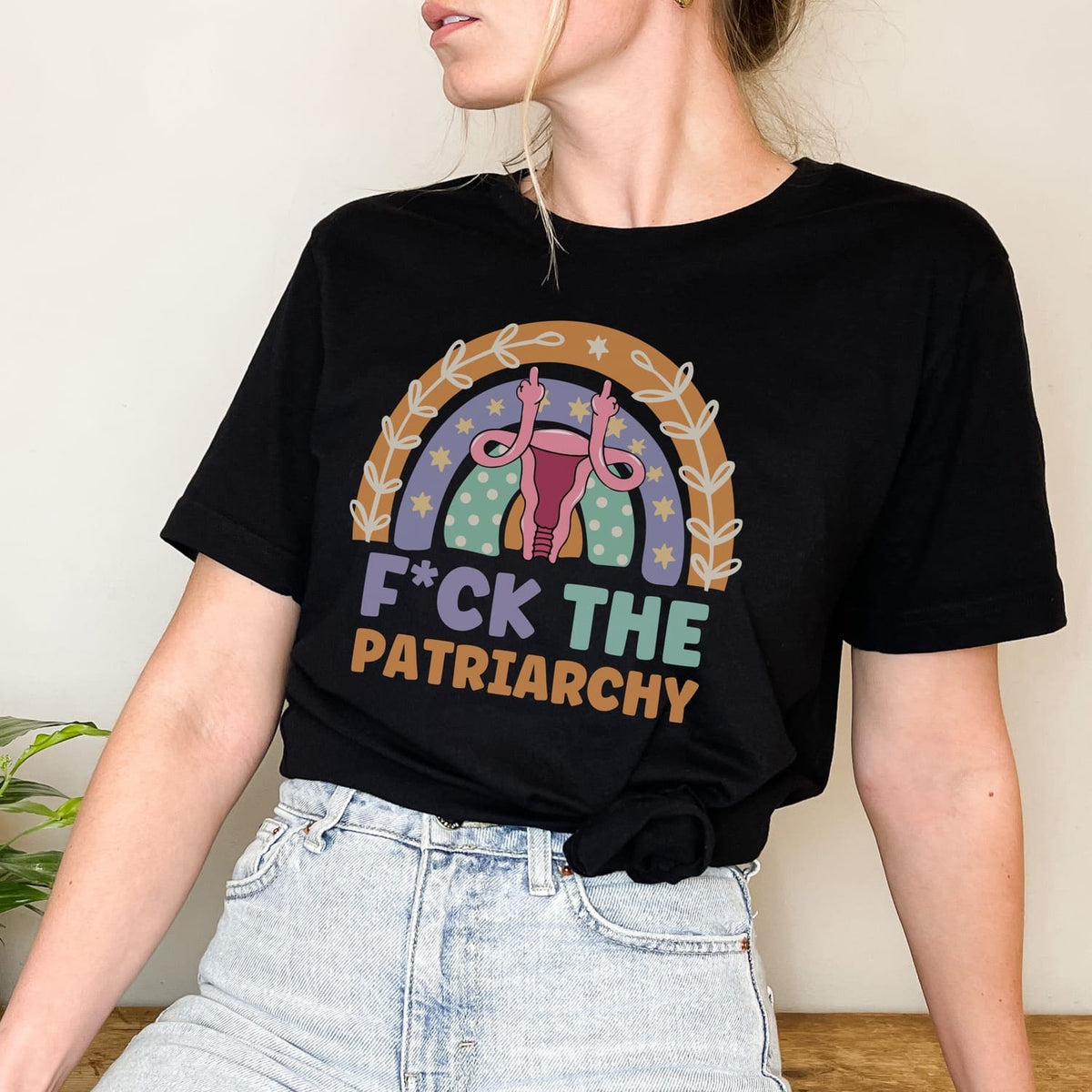 Person wearing a black t-shirt with a feminist graphic and text.