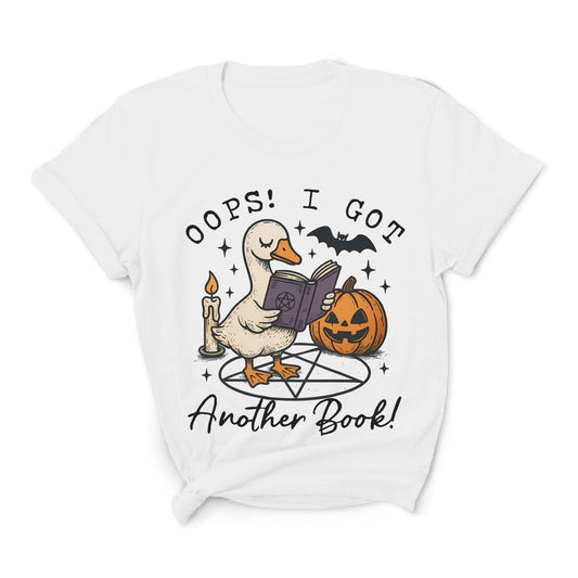 White t-shirt with Halloween-themed graphic of a duck holding a book, pumpkin, and candle: Funny Bookish Goose Shirt, Spooky Season Book Tee, Fall Library T-Shirt, Reading Gift For Halloween Lover Cute Trick Or Treat Teacher Outfit