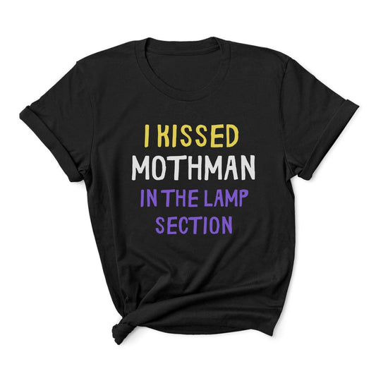 Black t-shirt with colorful text 'I KISSED MOTHMAN IN THE LAMP SECTION' on a white background: Nonbinary Humor Shirt, Funny Mothman Cryptid Tee, Spooky Queer Pride Gift, LGBTQ Meme T-Shirt ,Enby Weirdcore Top, Cryptidcore Mythology