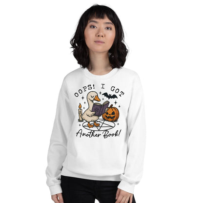 Person wearing a white bookish halloween sweatshirt with a graphic design and text on a white background