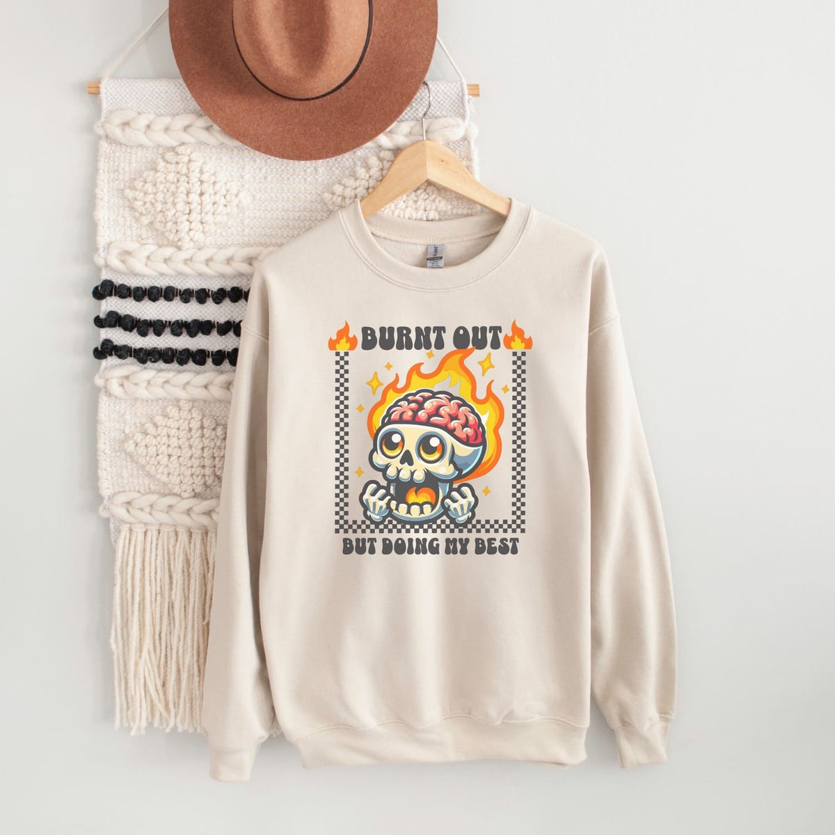 Beige burnout sweatshirt with skull design and text on a white background