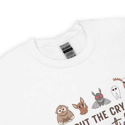 White sweatshirt with cryptid characters and text on a white background
