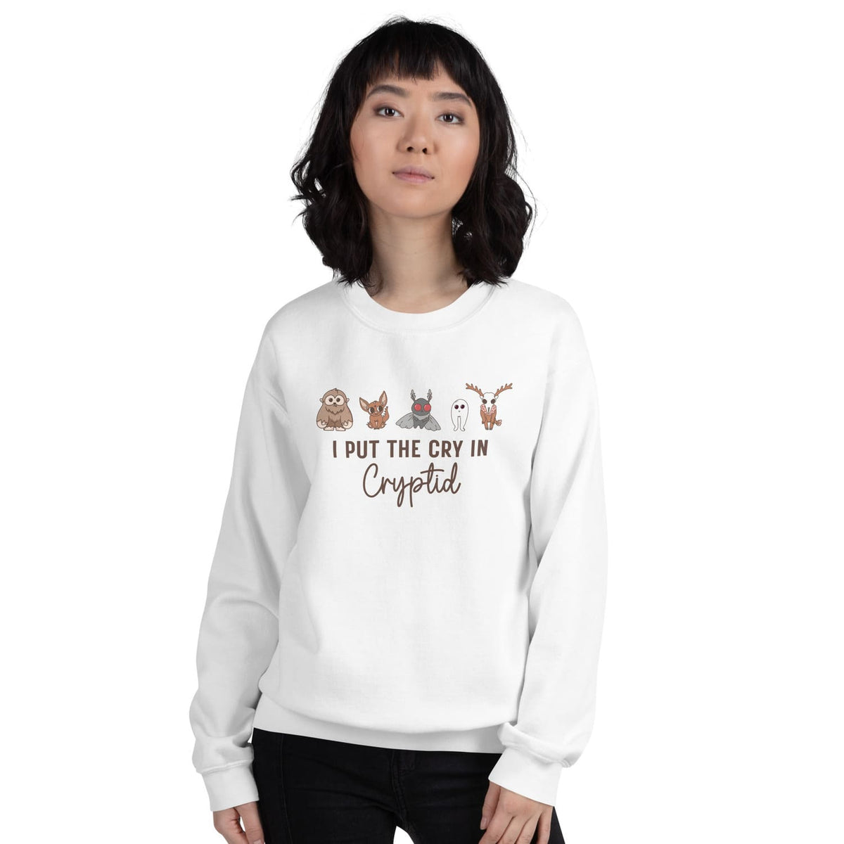 Person wearing a white sweatshirt with cryptid characters and text on a white background