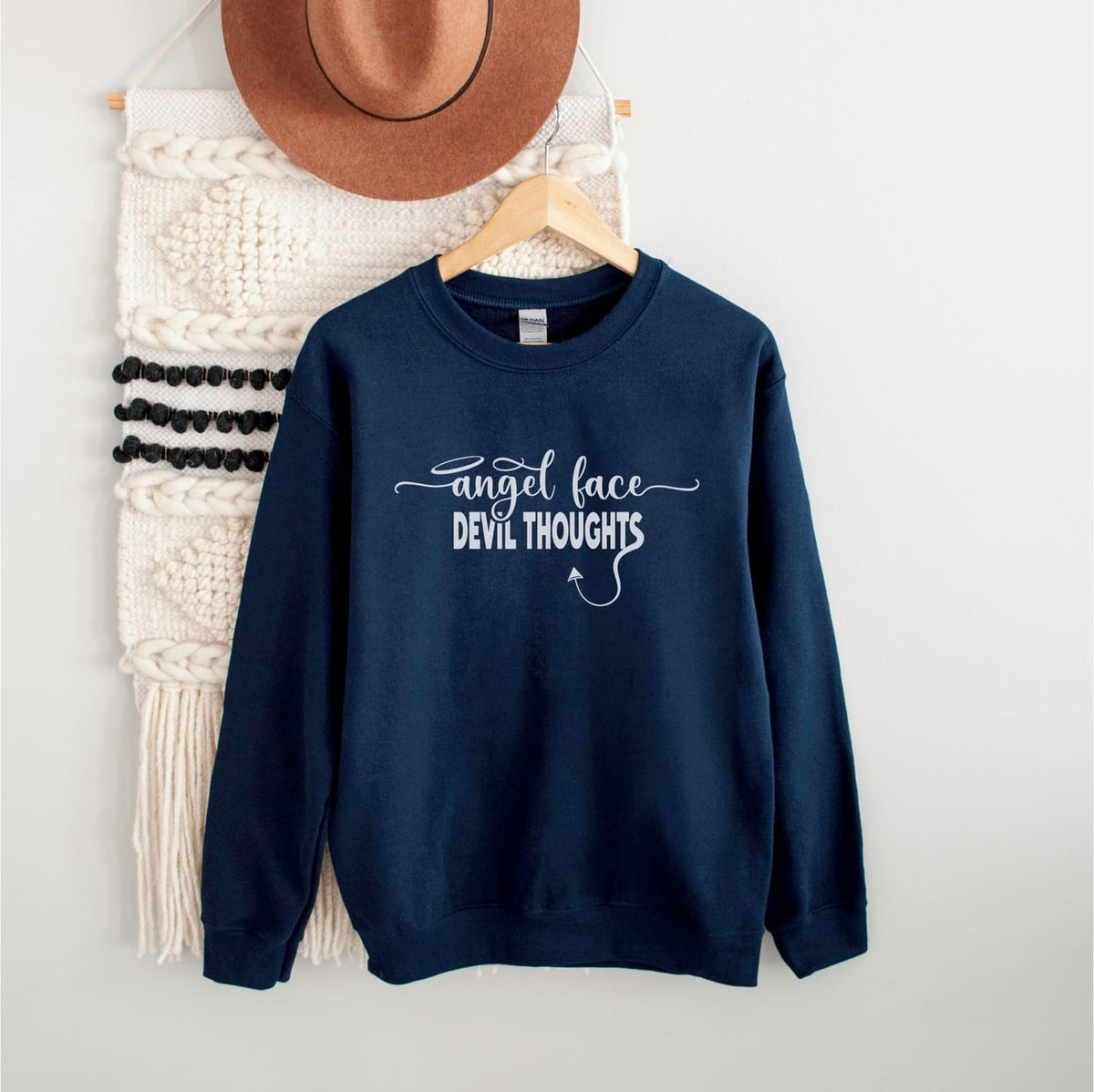 Funny naughty sweatshirt with text angel face devil thoughts, navy, hanging
