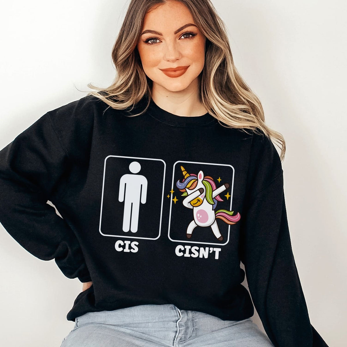 non cisgender person wearing a black queer sweatshirt with a unicorn graphic and text on a white background