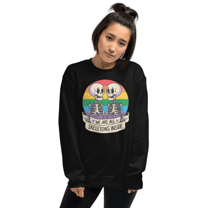 Person wearing a black sweatshirt with a rainbow lgbtq skeleton design and rainbow flag on a white background