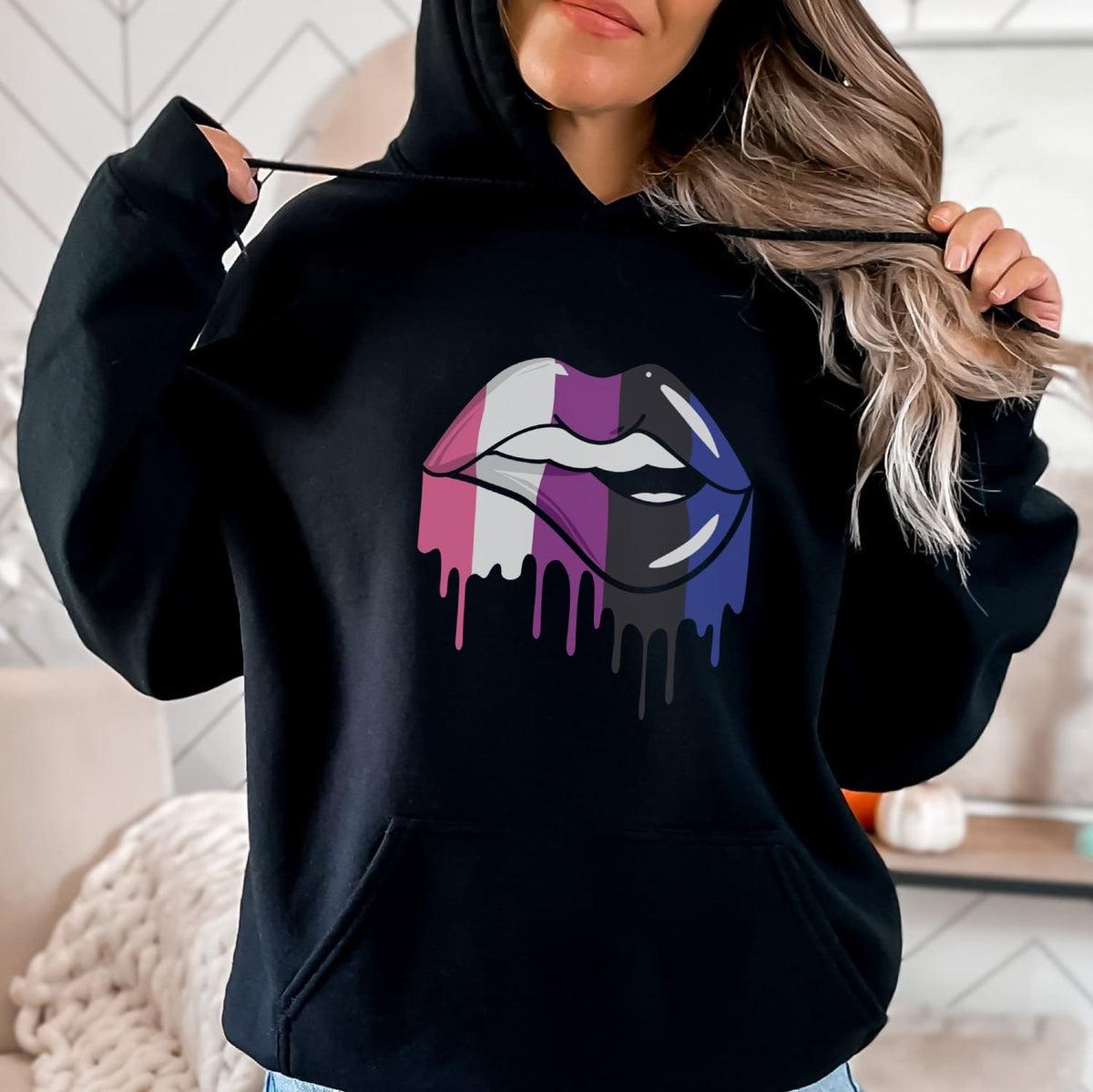 Person wearing a black hoodie with a colorful genderfluid lips design.