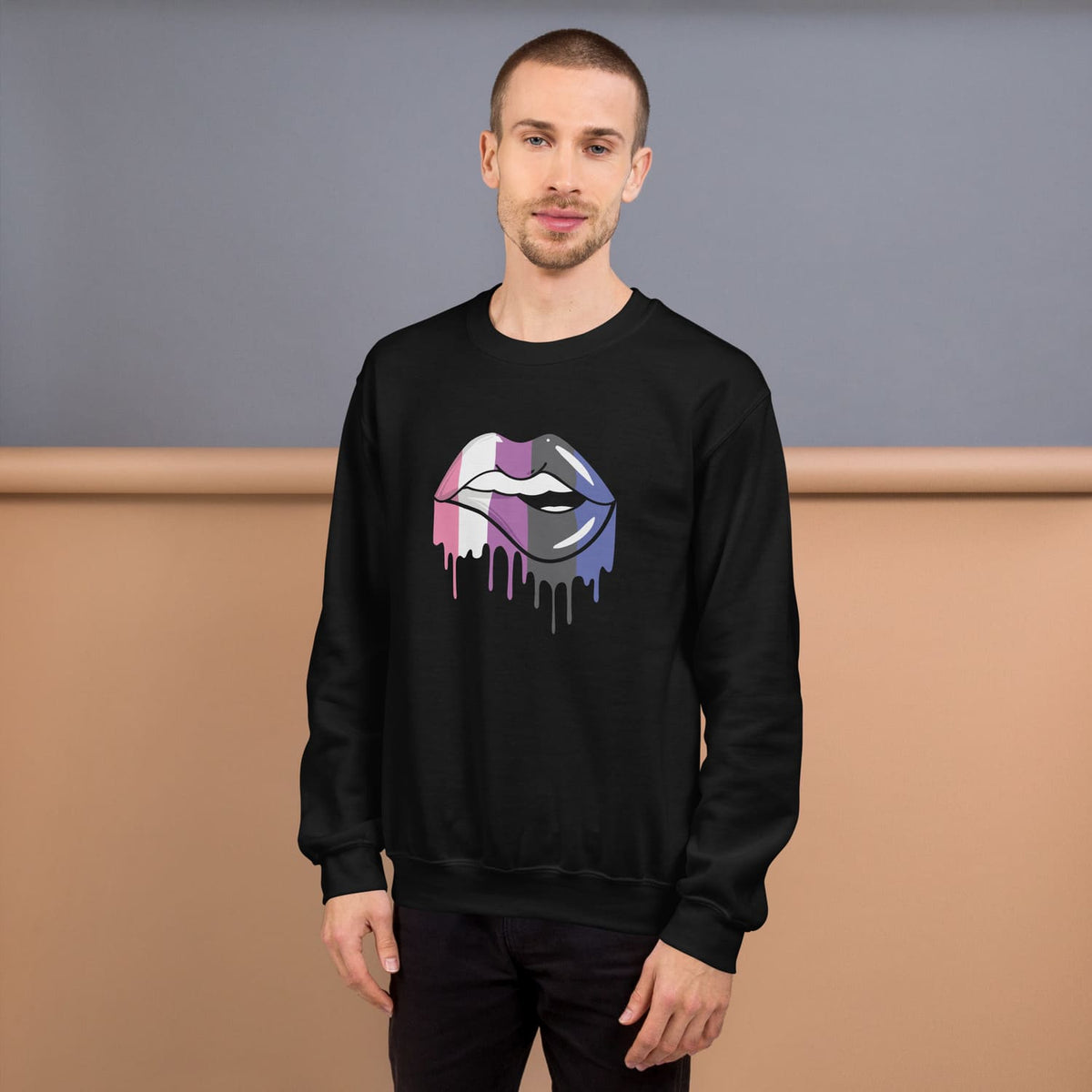Genderfluid wearing a black sweatshirt with a colorful lips graphic design against a plain background