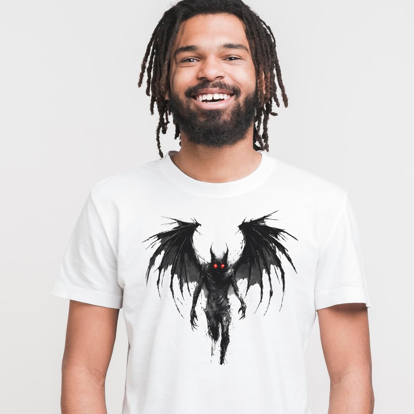 Man wearing a white t-shirt with mothman graphic design on a plain background