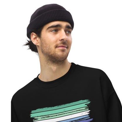 Man wearing a black beanie and black MLM sweatshirt with a colorful design on a white background