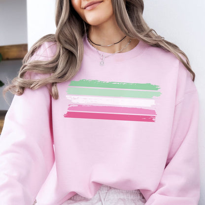 Person wearing a pink abrosexual sweatshirt with green and pink horizontal stripes.