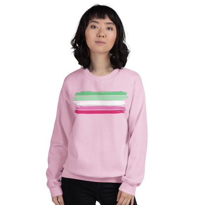 Person wearing a pink abrosexual sweatshirt with colorful stripes on a white background