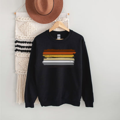 Black bear pride sweatshirt with grunge flag on a hanger against a white wall.