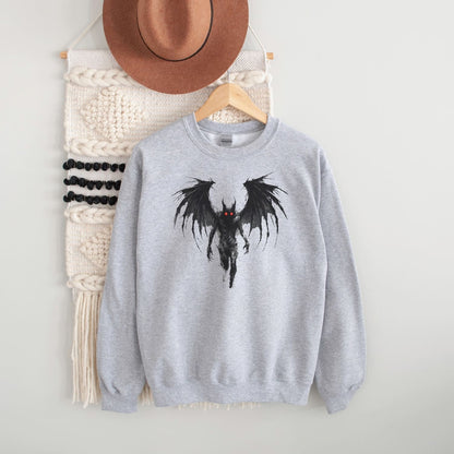 Gray sweatshirt with a mothman design on a hanger against a white wall.