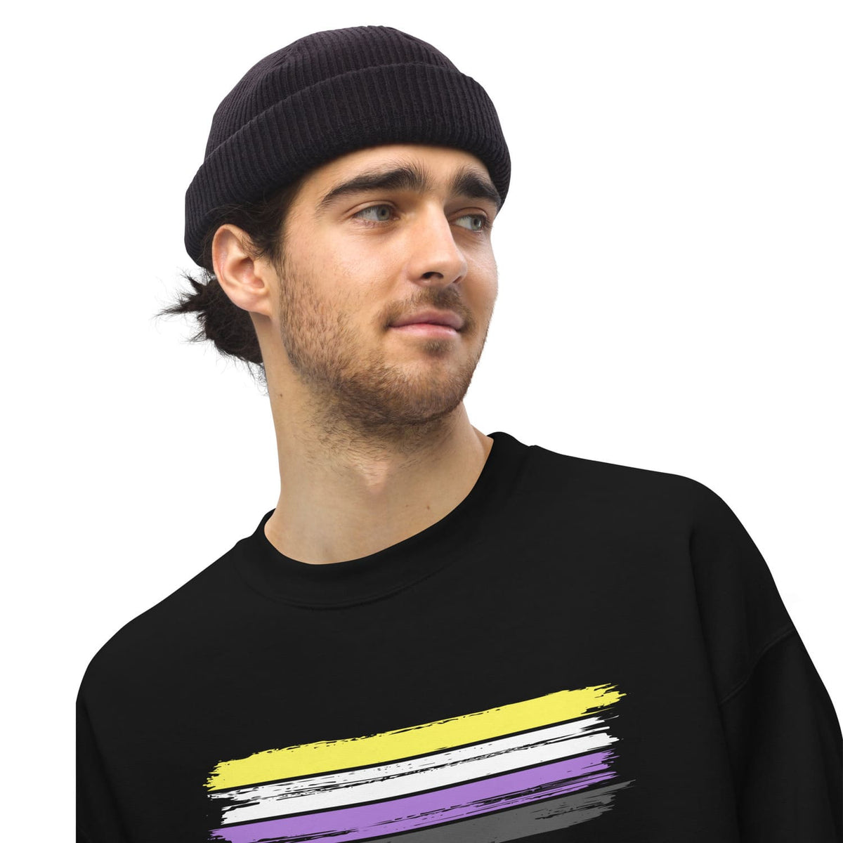 Man wearing a black beanie and black nonbinary sweatshirt with a colorful design on a white background