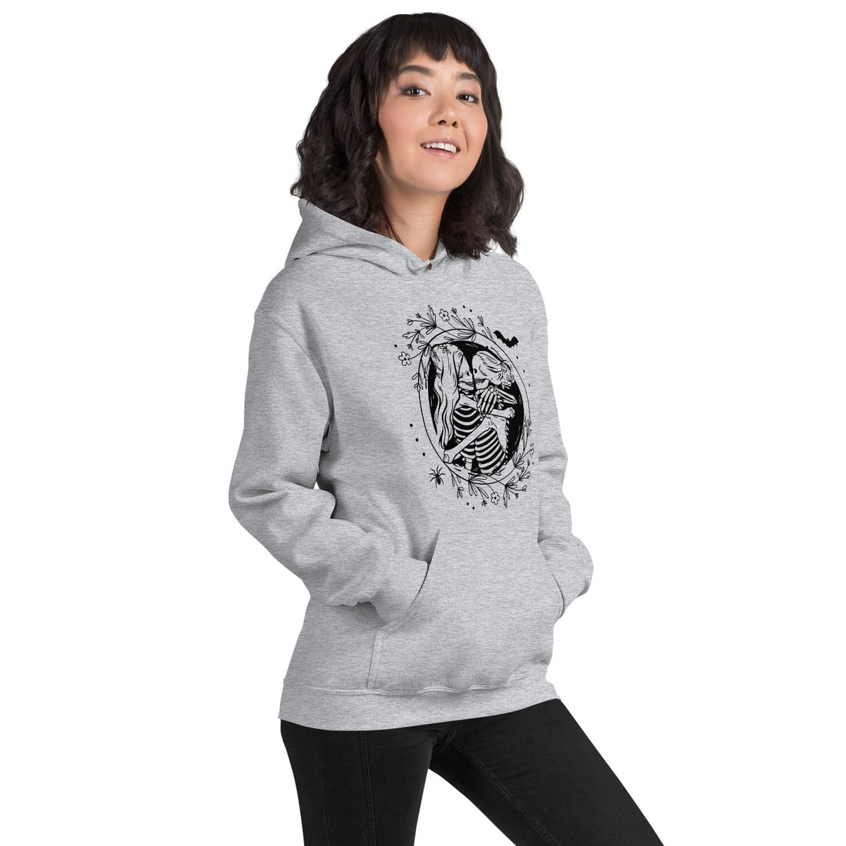 Person wearing a gray hoodie with hugging lesbian skeleton couple on a white background