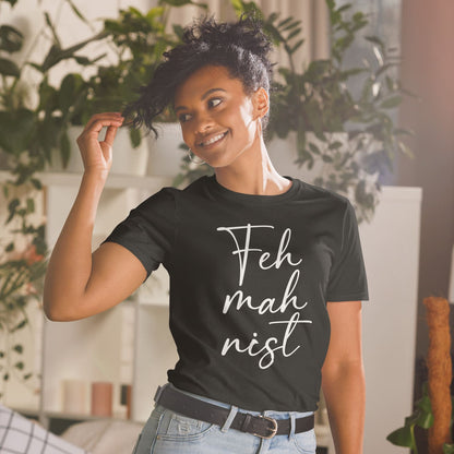 Woman wearing a black feminist t-shirt with 'Feh mah nist' text in a casual setting