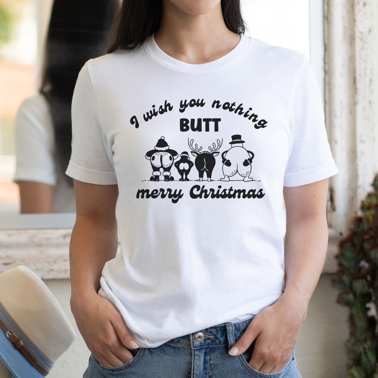 Person wearing a white t-shirt with a humorous Christmas design and text.