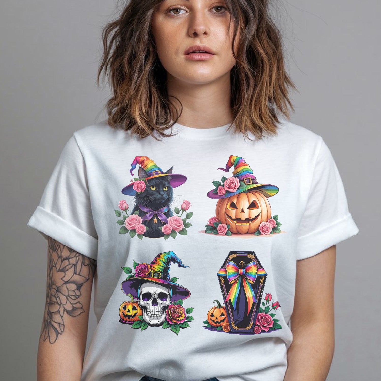 Person wearing a white t-shirt with LGBT pride Halloween-themed designs including a black cat, pumpkin, skull, and coffin.