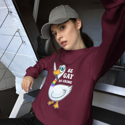 Person wearing a maroon LGBTQ activist sweatshirt with agoose graphic design and text, sitting on steps.