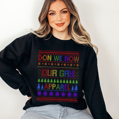 Person wearing a christmas pride sweater with rainbow text and patterns on a plain background