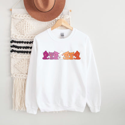 White lesbian sweatshirt with colorful cat graphic on a hanger against a white background