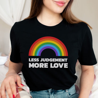 Person wearing a black pride t-shirt with a rainbow and text 'LESS JUDGEMENT MORE LOVE'.