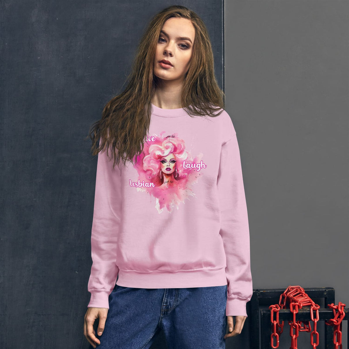 Woman wearing a pink lesbian sweatshirt with a graphic design on a dark background