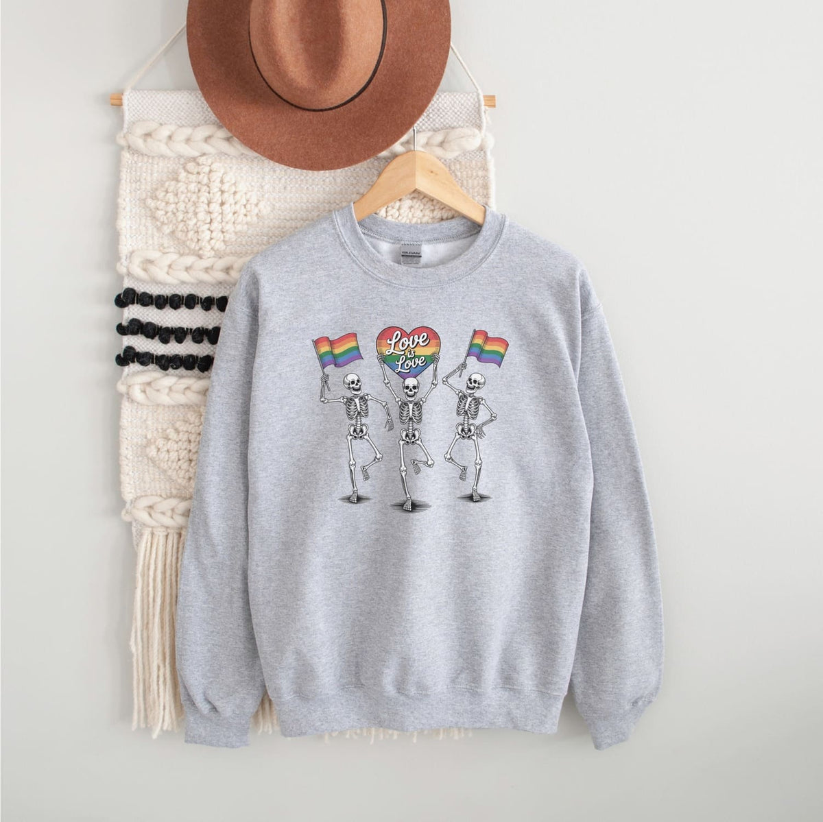 Gray sweatshirt with skeleton design and rainbow flags 'love is love' on a white background