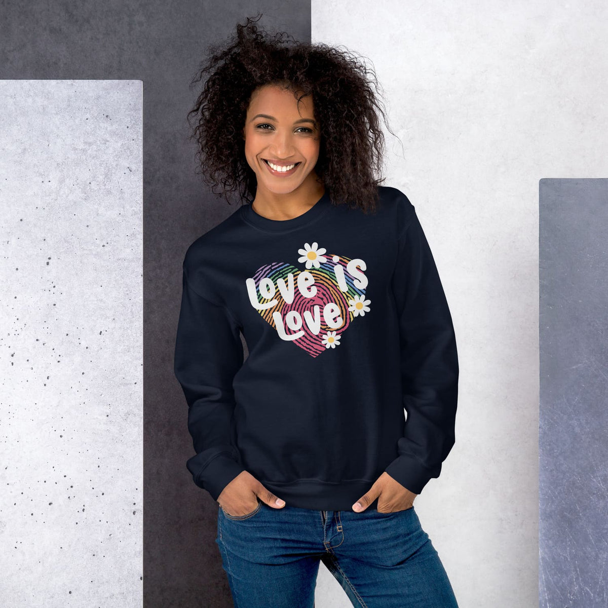 Woman wearing a navy blue pride lgbt sweatshirt with love is love on a gray and white background