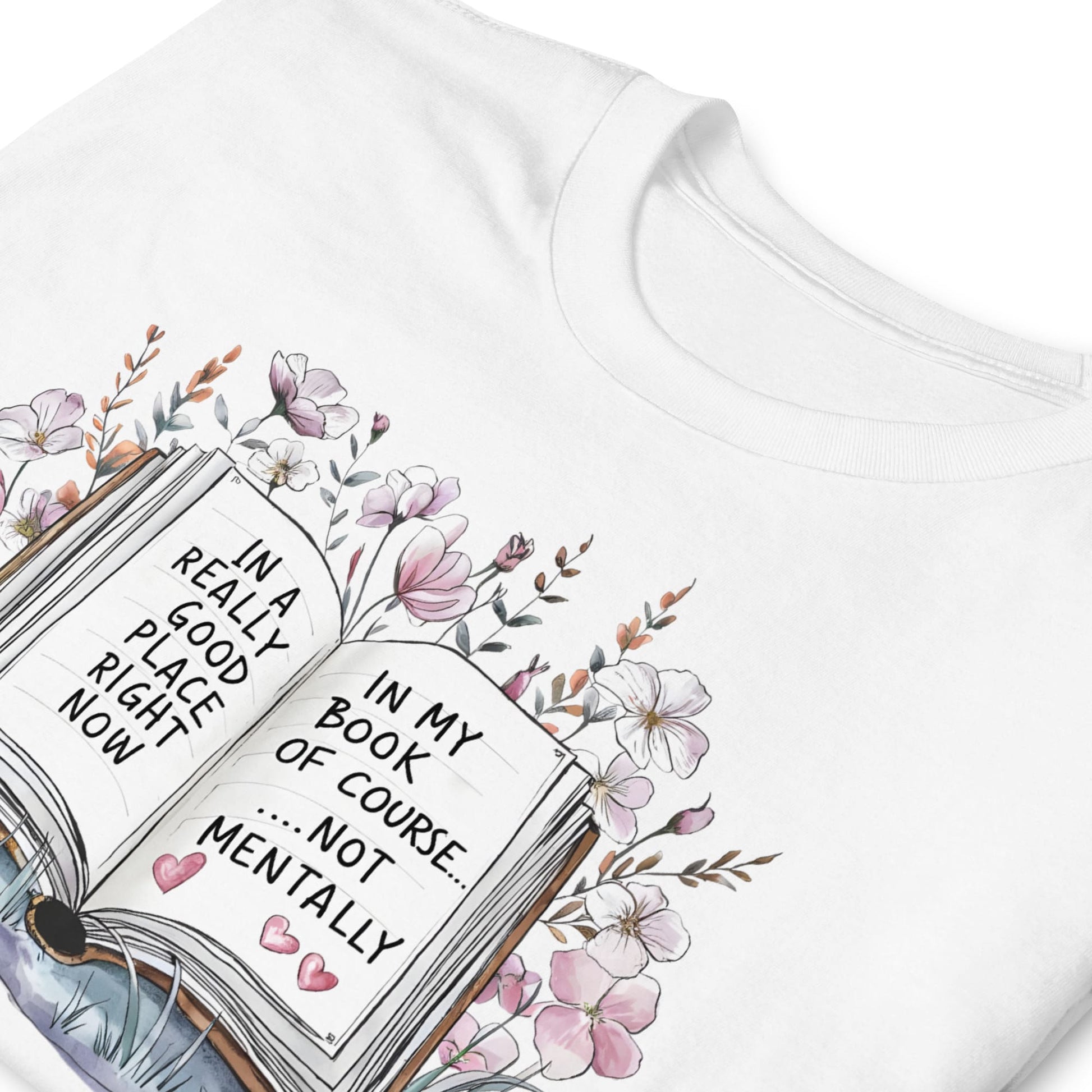 White t-shirt with an open book graphic and floral design, featuring text.