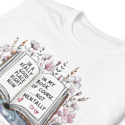 White t-shirt with an open book graphic and floral design, featuring text.
