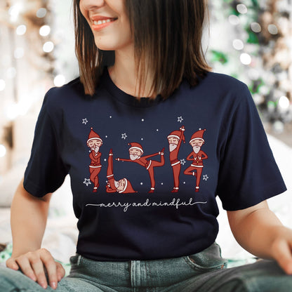 Person wearing a navy blue t-shirt with Christmas-themed design featuring Santa Claus in various yoga poses.