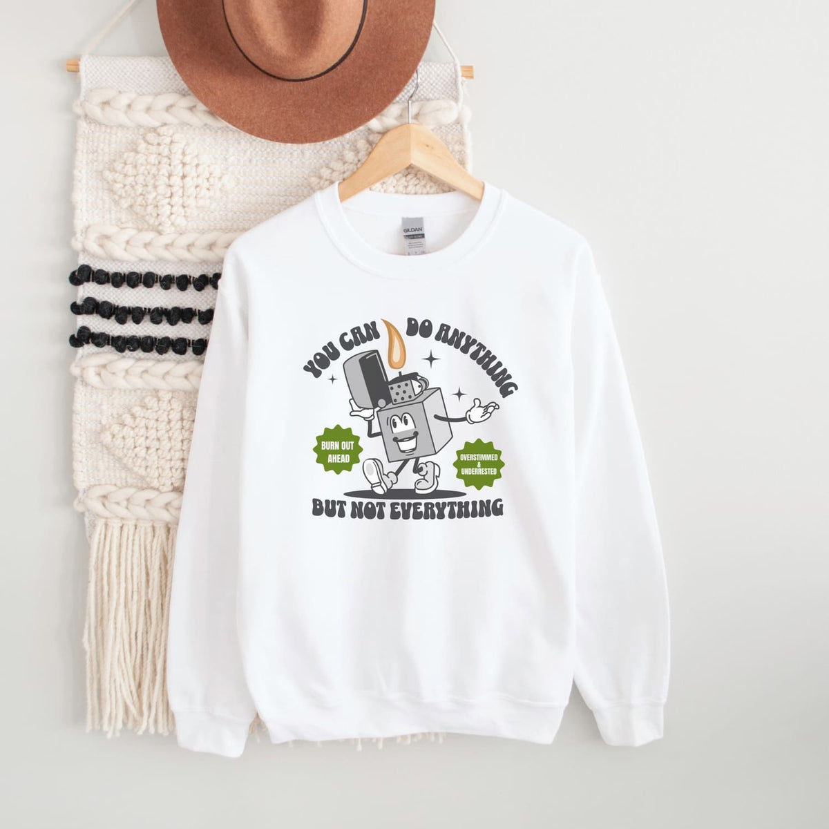 White burnout sweatshirt with a graphic design on a hanger against a white background