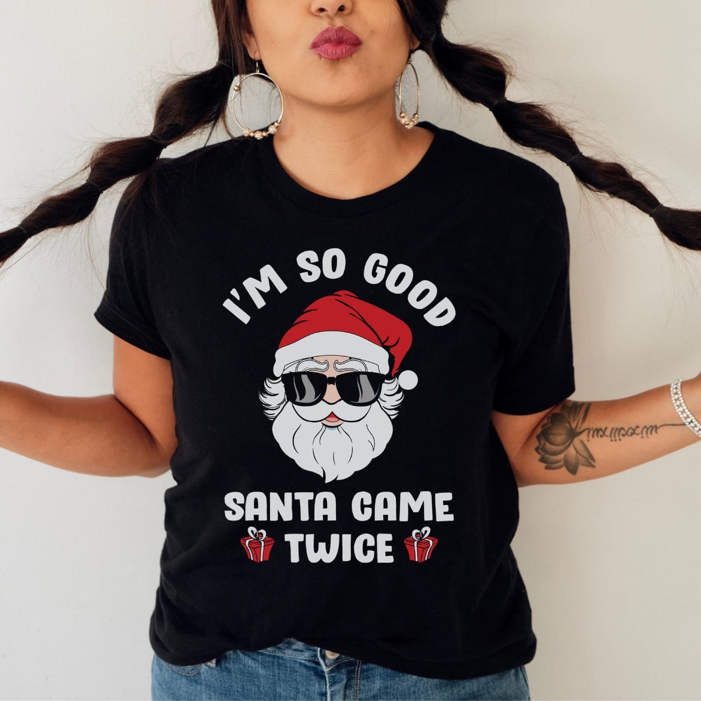 Person wearing a black t-shirt with a Santa Claus graphic and text.