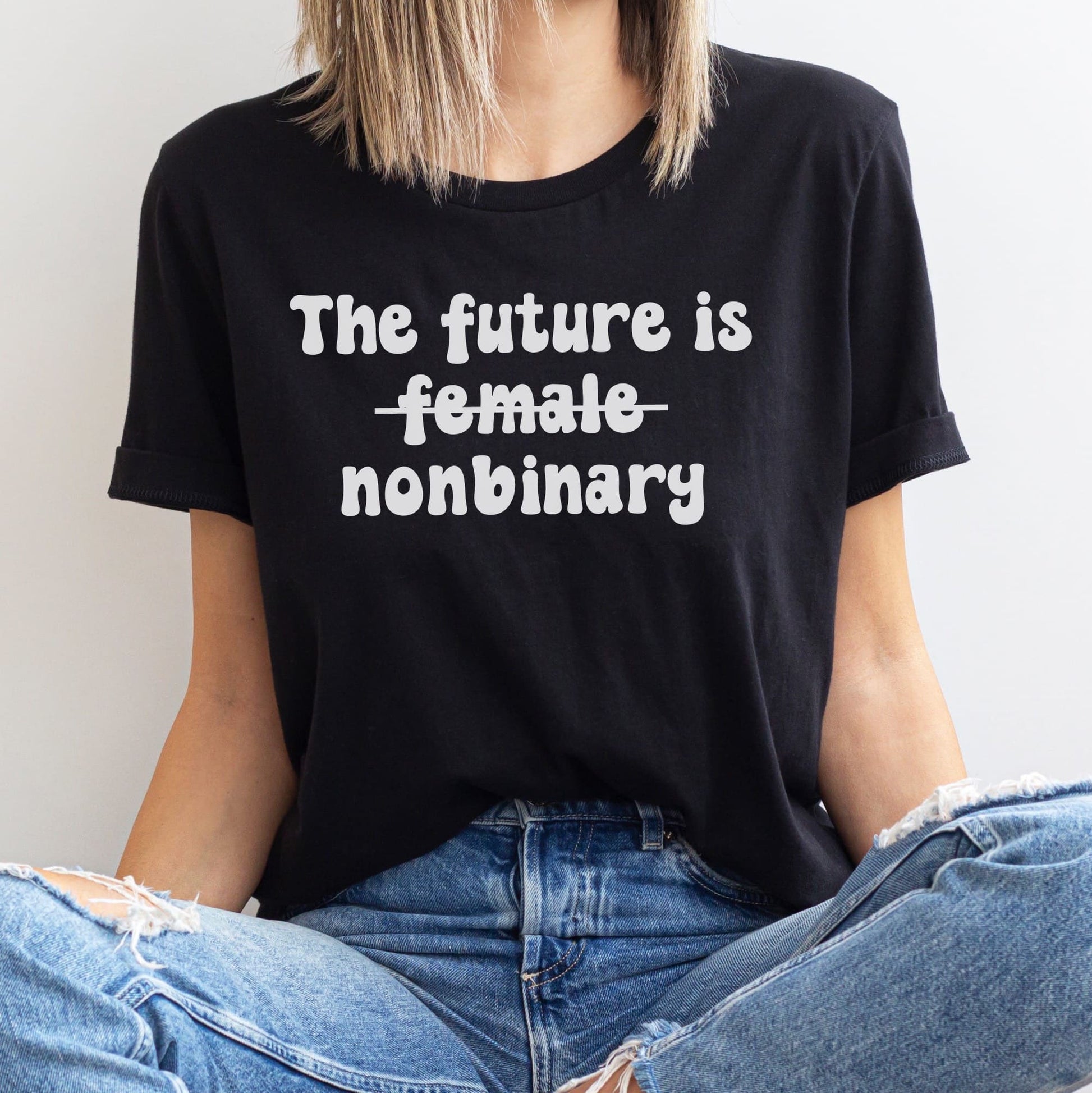Person wearing a black t-shirt with 'The future is female nonbinary' text.