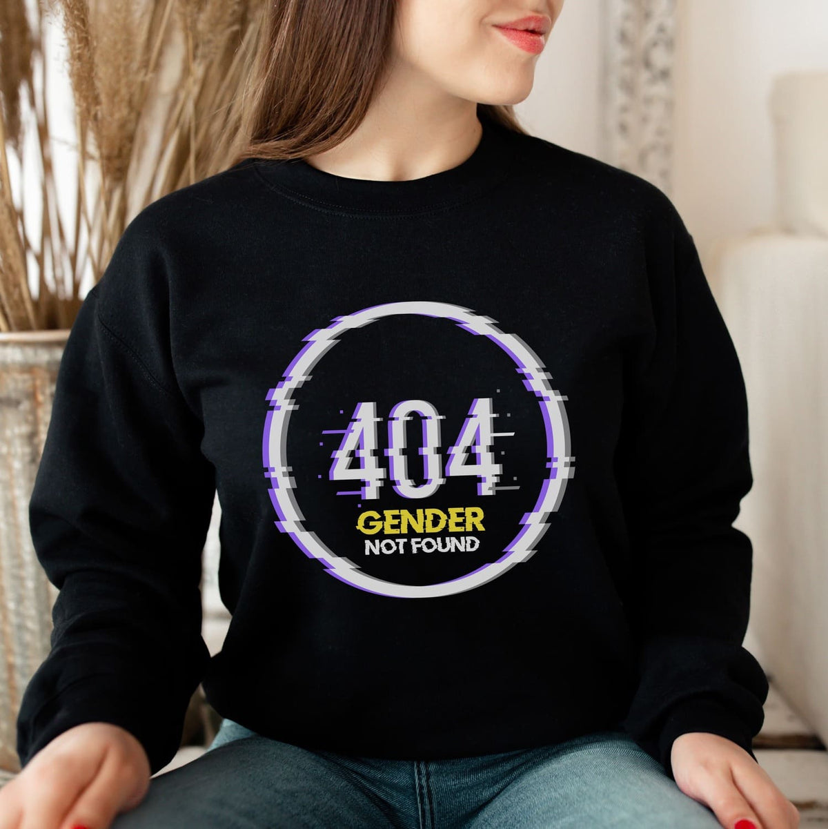 nonbinary Person wearing a black sweatshirt with '404 Gender Not Found' design.