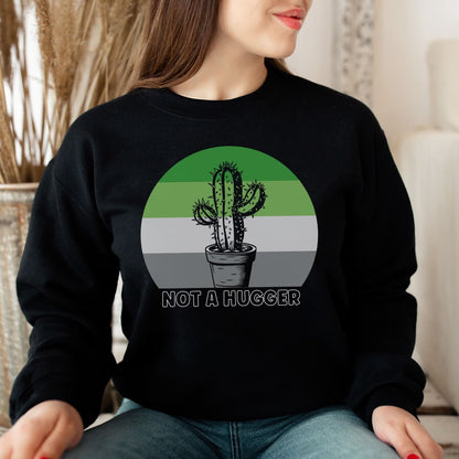 Person wearing a black aromantic sweatshirt with a cactus graphic and 'Not a Hugger' text.