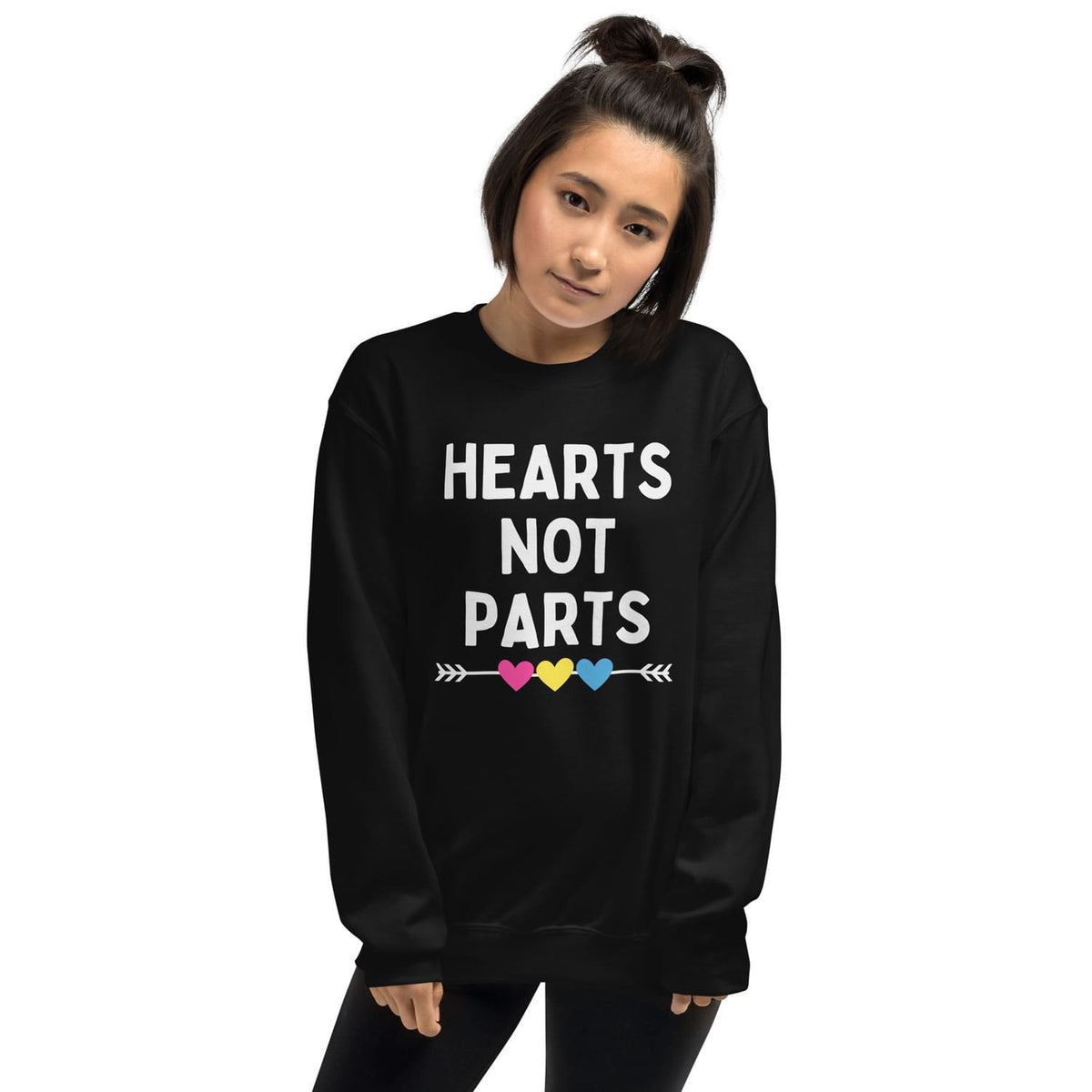 Person wearing a black pansexual sweatshirt with 'Hearts Not Parts' text and colorful heart symbols.