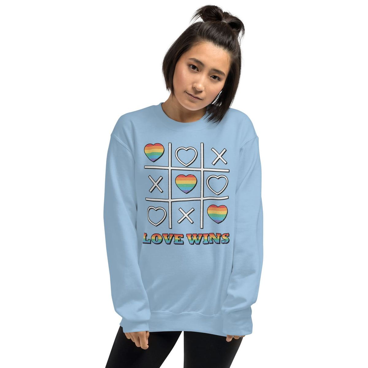 Person wearing a light blue LGBTQ pride sweatshirt with a rainbow design and 'LOVE WINS' text on a white background