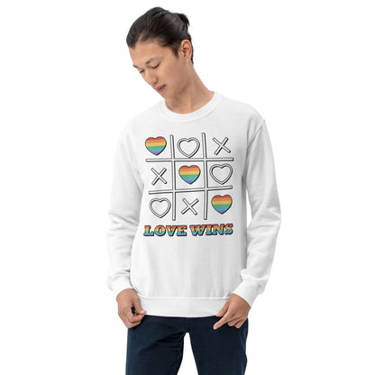Person wearing a white LGBT pride sweatshirt with rainbow heart and cross design and 'LOVE WINS' text on a white background