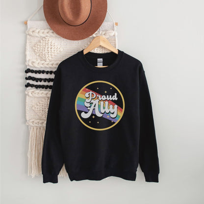 Black sweatshirt with 'Proud Ally' rainbow design on a hanger against a white wall.