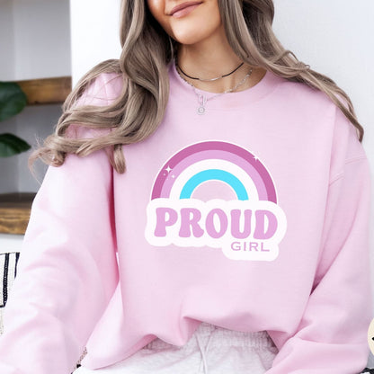 Person wearing a pink sweatshirt with a rainbow and 'PROUD GIRL' text design.