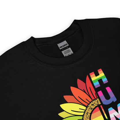 Detail of pride sweatshirt with a colorful sunflower design and 'HUMAN' text on a white background