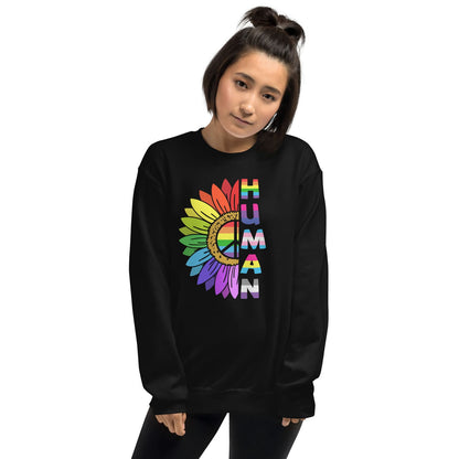 Person wearing a black LGBTQ pride sweatshirt with a colorful 'HUMAN' design on a white background