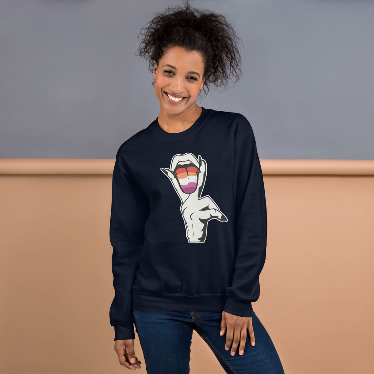 Lesbian wearing a navy blue sweatshirt with a graphic design on a beige and gray background